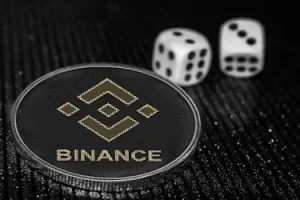 A coin branded with Binance logo along with two dice